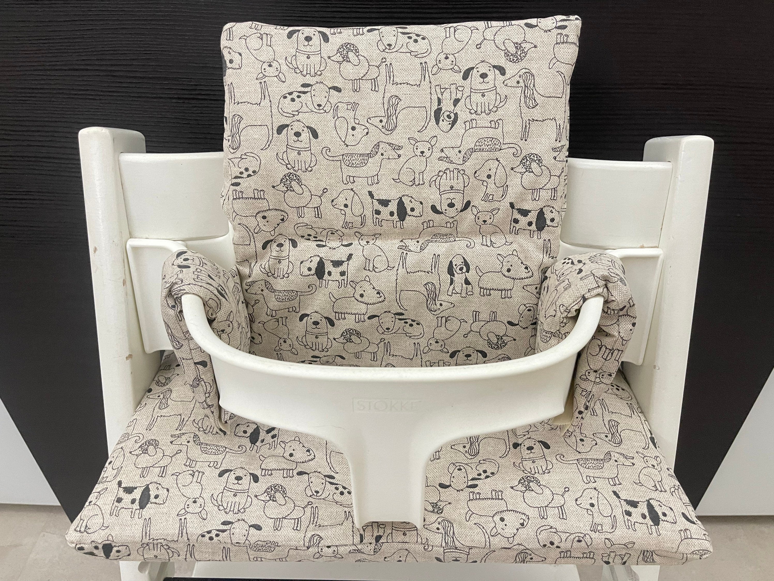 Frontansicht vom Handgemachten Sitzkissen Set für den Stokke Tripp Trapp Hochstuhl in Beige mit schwarzen Hunden, abwaschbares Material